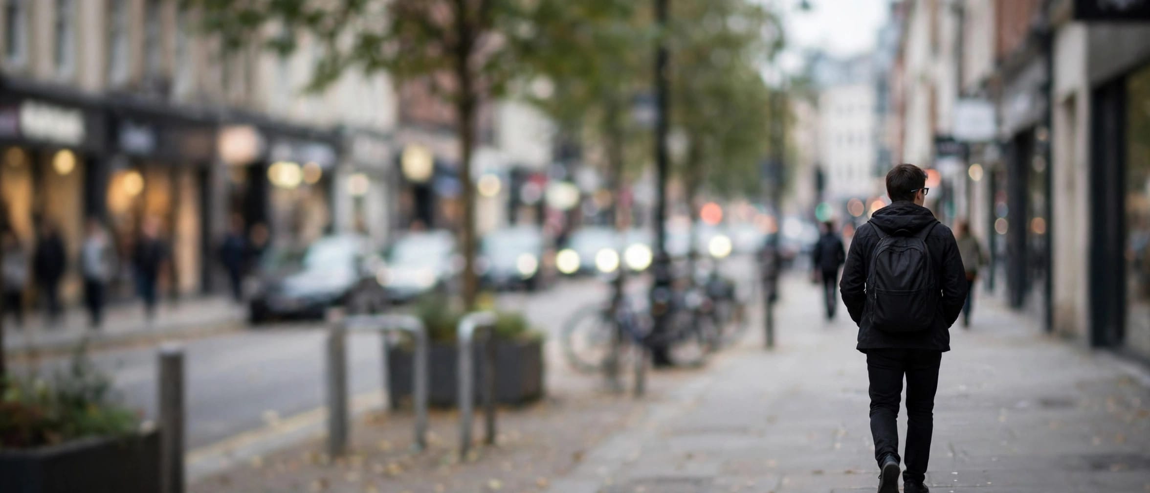 Person wearing smart glasses on a city street, face not identifiable